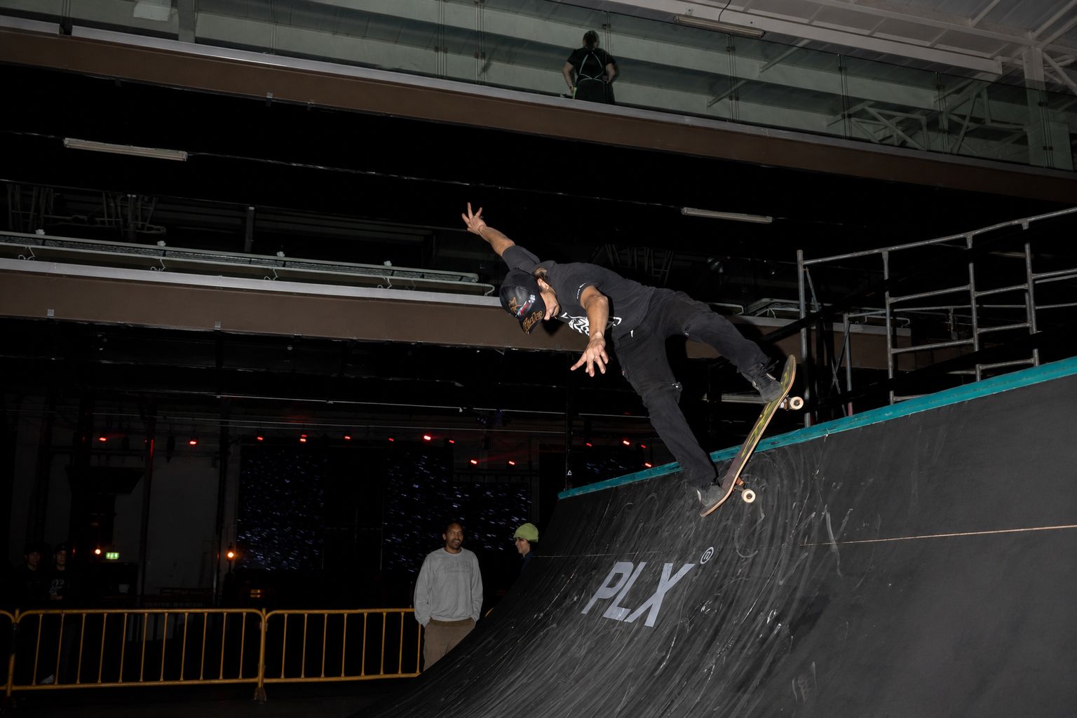 Skater en el aire sobre la rampa durante un evento de skate bajo techo